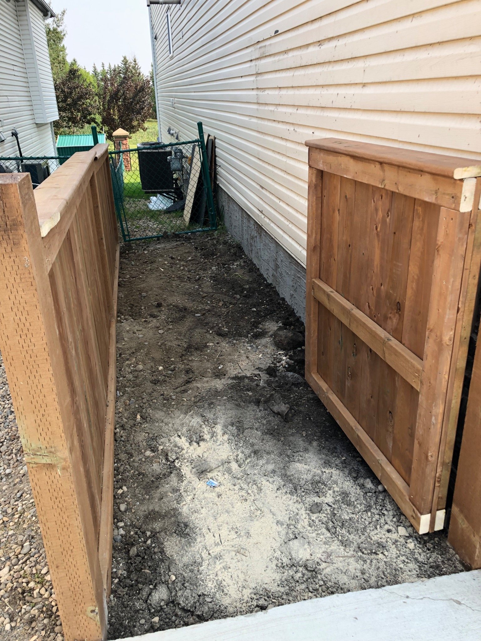 Open treated wood gate showing enclosed bin storage area